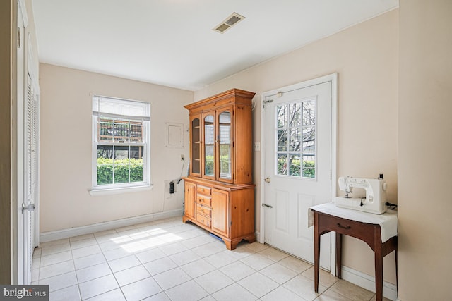 doorway featuring baseboards, visible vents, and light tile patterned floors
