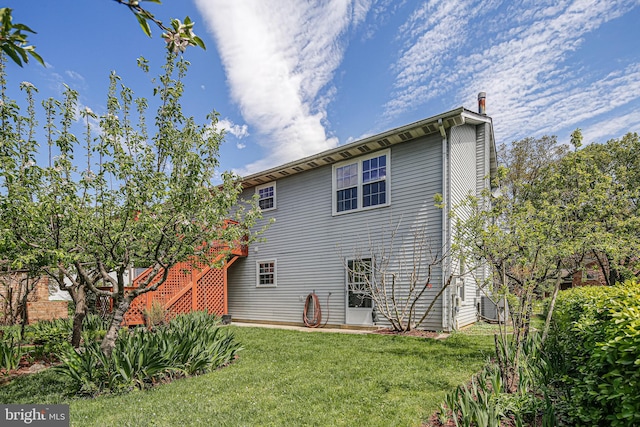 rear view of house featuring stairway and a yard