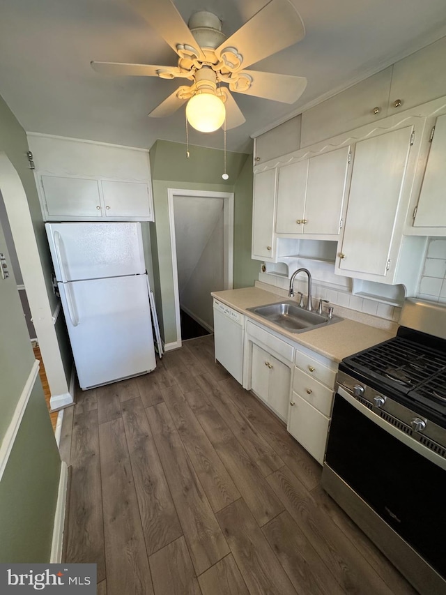 kitchen with a sink, dark wood-style flooring, light countertops, ceiling fan, and white appliances