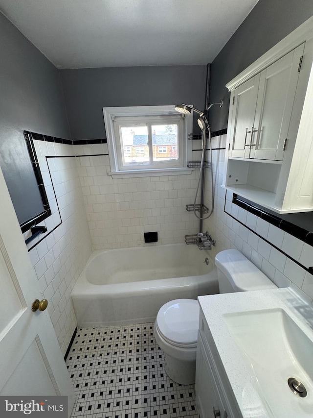 bathroom featuring shower / bath combination, vanity, tile walls, and toilet