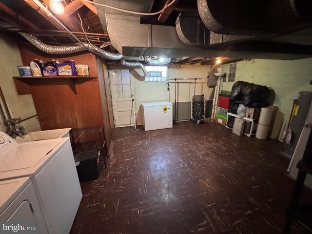 below grade area featuring washer and clothes dryer, dark floors, and refrigerator