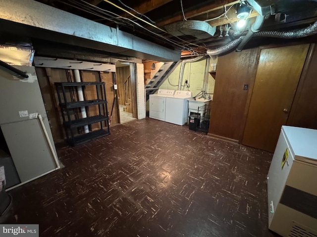 unfinished basement with tile patterned floors, stairway, independent washer and dryer, fridge, and a sink