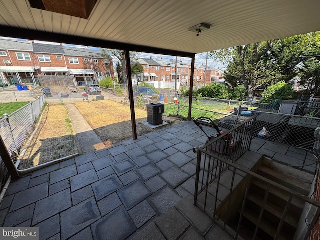 view of patio / terrace featuring a residential view, a fenced backyard, and cooling unit