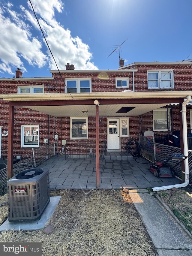 back of property featuring brick siding and central air condition unit