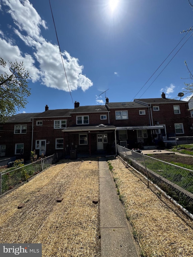 view of front of property with central AC unit and fence