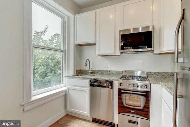 1674 Irving St NW, Washington, DC 20010 - kitchen featuring light stone counters, a sink, white cabinetry, and stainless steel appliances