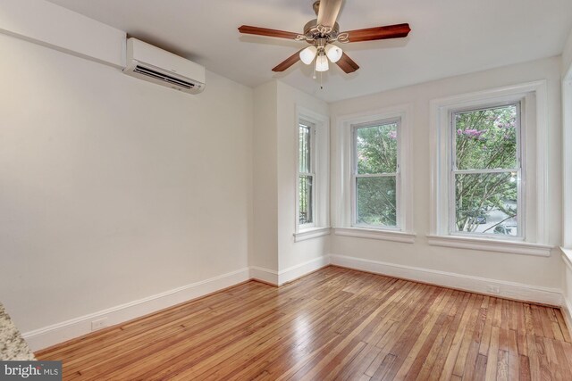 1674 Irving St NW, Washington, DC 20010 - spare room featuring baseboards, a wall mounted AC, ceiling fan, and light wood-type flooring