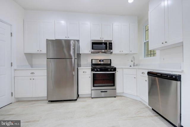 1674 Irving St NW, Washington, DC 20010 - kitchen with light countertops, stainless steel appliances, white cabinetry, and a sink