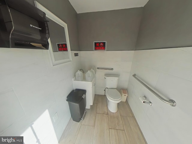 half bath with toilet and wood finished floors