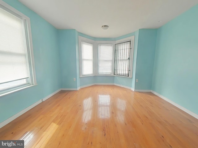 empty room featuring wood-type flooring and baseboards