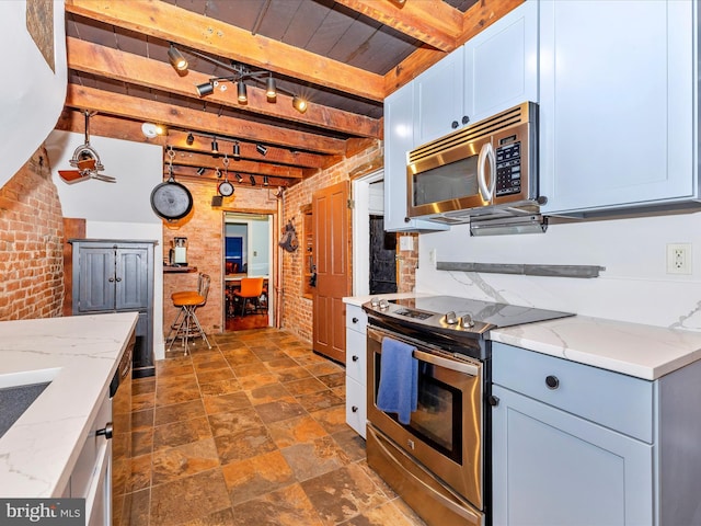 435S Market St, Frederick, MD 21701 - kitchen with beamed ceiling, appliances with stainless steel finishes, light stone counters, and brick wall