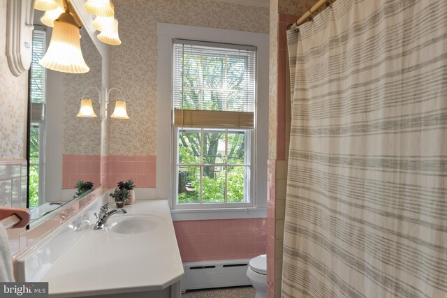 138 Charles St, Annapolis, MD 21401 - bathroom with a baseboard radiator, tile walls, wallpapered walls, a wainscoted wall, and vanity