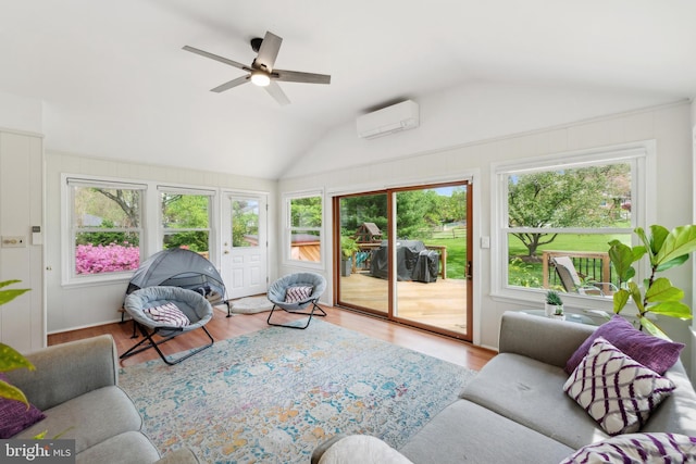 living area featuring vaulted ceiling, wood finished floors, ceiling fan, and an AC wall unit