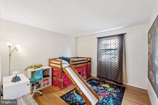 bedroom with wood finished floors and baseboards