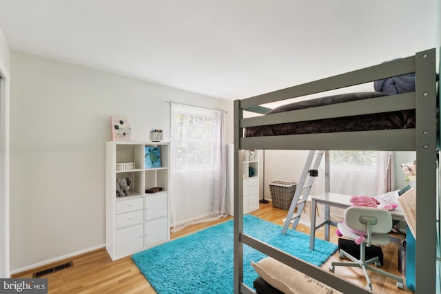 bedroom featuring visible vents, baseboards, and light wood-style floors