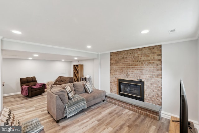 living room featuring crown molding, baseboards, wood finished floors, and a fireplace