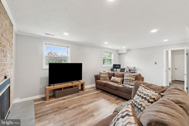 living area with recessed lighting, ornamental molding, wood finished floors, and a brick fireplace