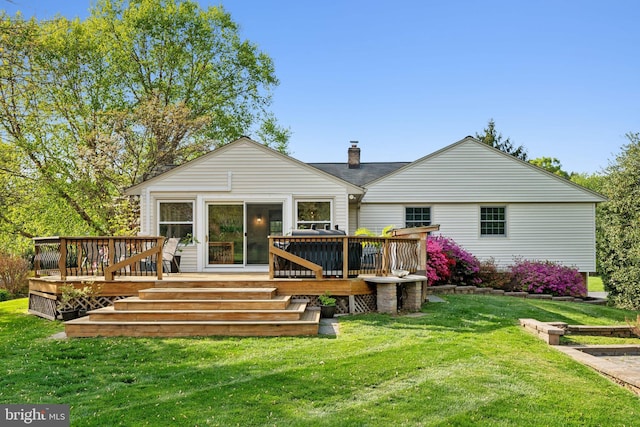 back of property featuring a deck, a yard, and a chimney