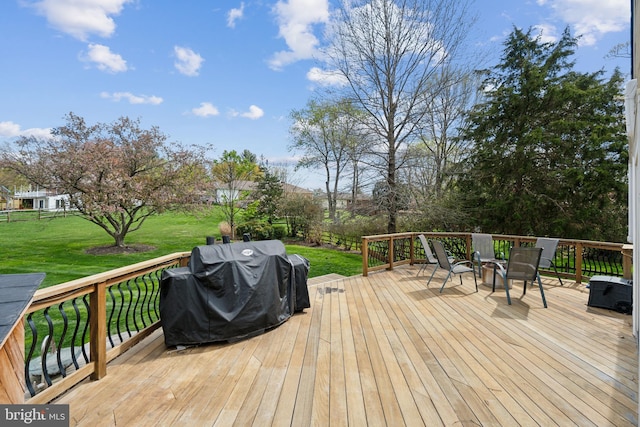 deck with a lawn and grilling area
