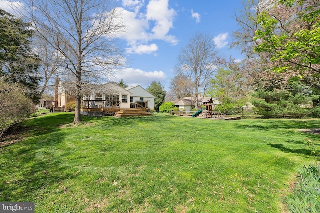 view of yard with a deck and a playground