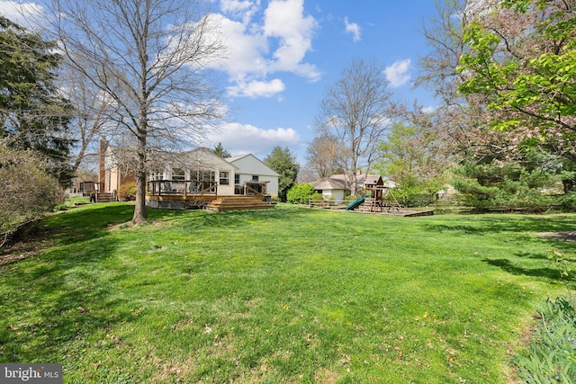 view of yard with a deck and a playground