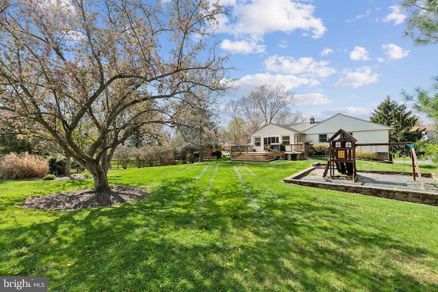 view of yard with a wooden deck and a playground