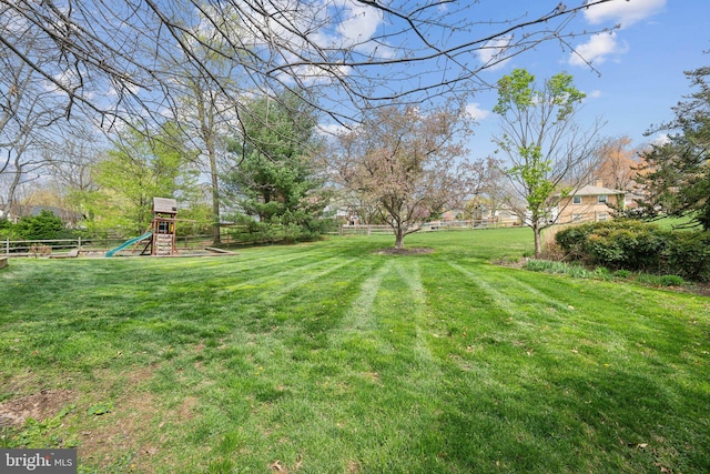 view of yard featuring fence and a playground