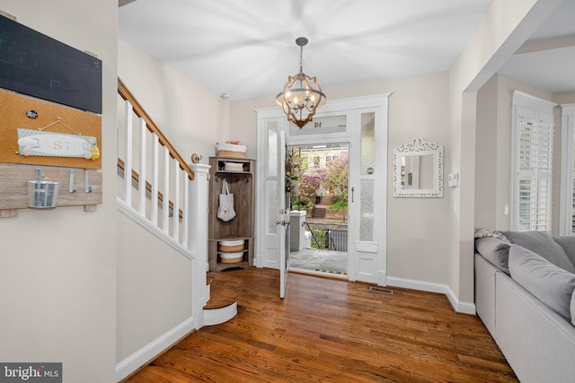 510 Quincy St NW, Washington, DC 20011 - entryway with baseboards, an inviting chandelier, stairs, visible vents, and wood finished floors