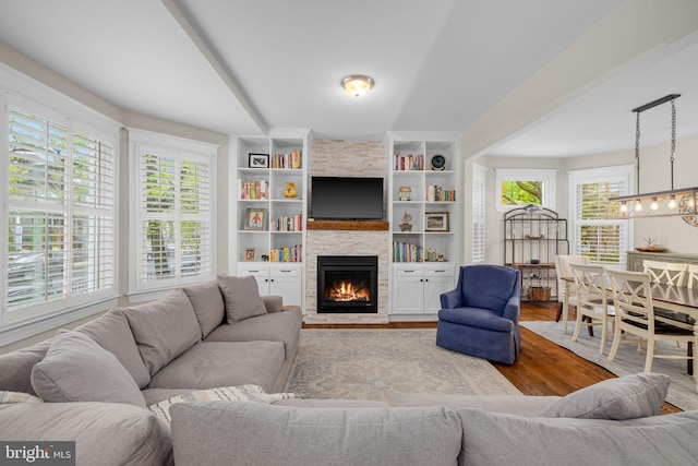 510 Quincy St NW, Washington, DC 20011 - living room featuring a chandelier, wood finished floors, a stone fireplace, and built in features
