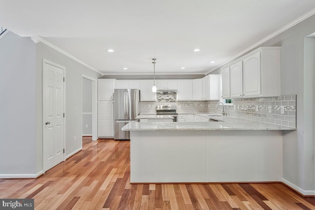 kitchen with stainless steel appliances, a peninsula, a sink, light wood finished floors, and crown molding
