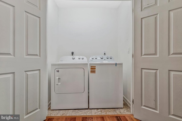 laundry room with washer and clothes dryer, light wood finished floors, and baseboards