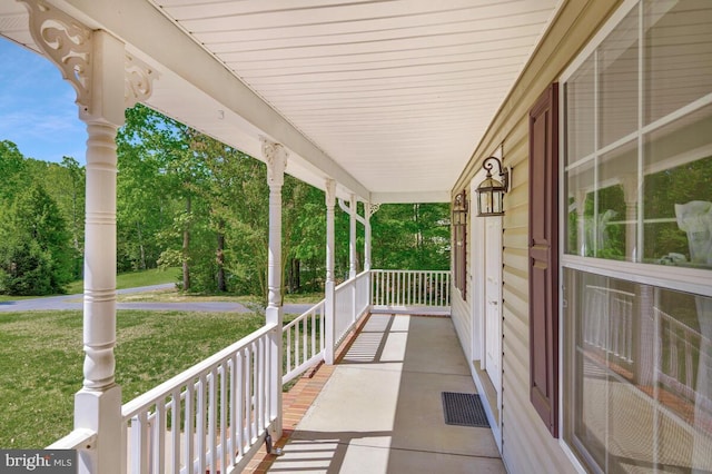 view of patio / terrace featuring a porch and view of scattered trees
