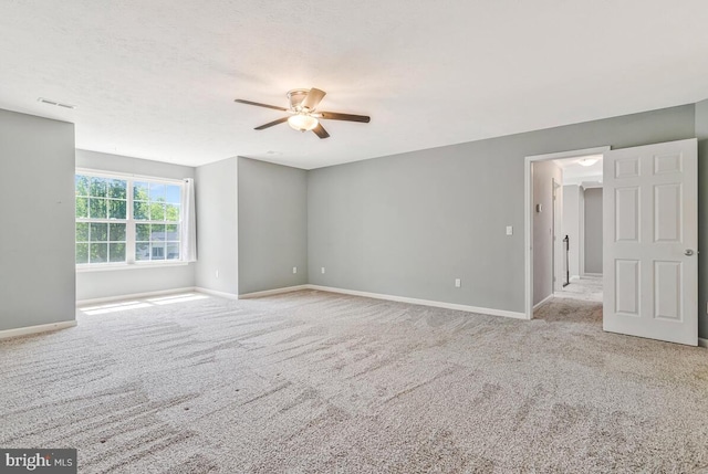 empty room with a ceiling fan, baseboards, and carpet floors
