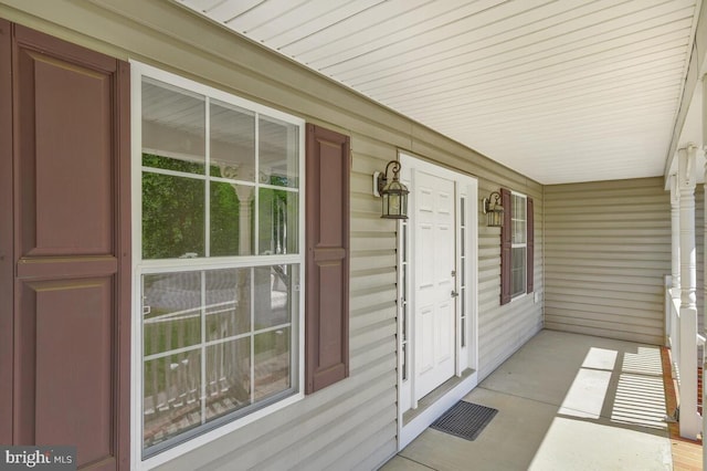 view of exterior entry featuring covered porch