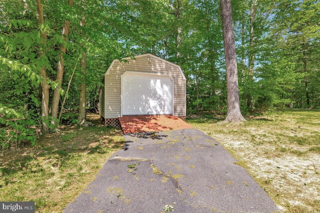 view of outdoor structure featuring an outbuilding and asphalt driveway
