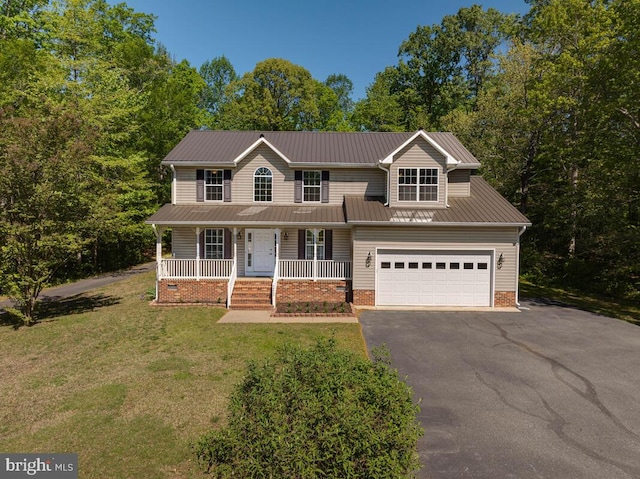 view of front of house with covered porch, asphalt driveway, a front lawn, metal roof, and a garage