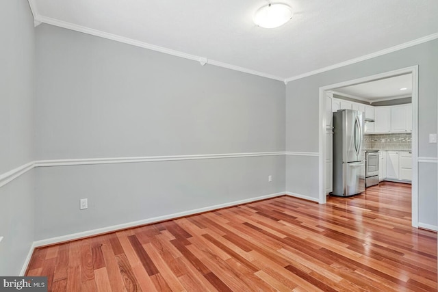 unfurnished bedroom with freestanding refrigerator, light wood-style floors, ornamental molding, and baseboards