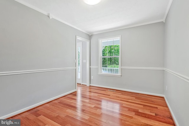 unfurnished room with ornamental molding, wood finished floors, and baseboards