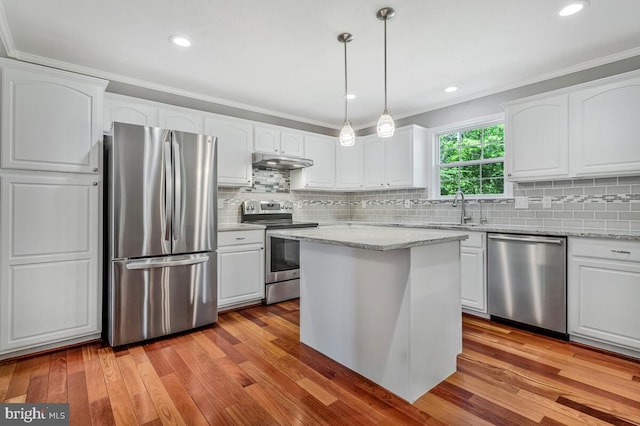 kitchen with stainless steel appliances, under cabinet range hood, a sink, white cabinetry, and light wood-style floors