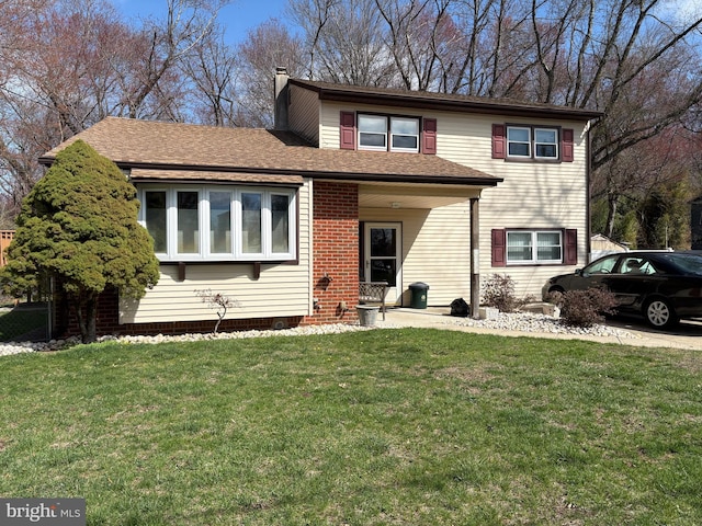 view of front facade featuring a front yard and a shingled roof
