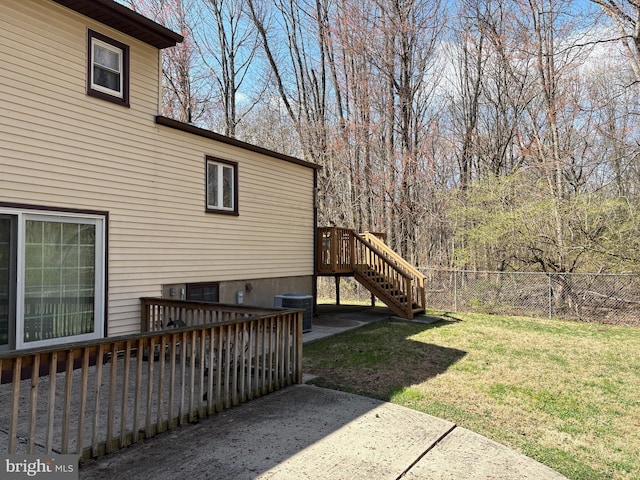 exterior space featuring a wooden deck, cooling unit, a yard, fence, and stairs
