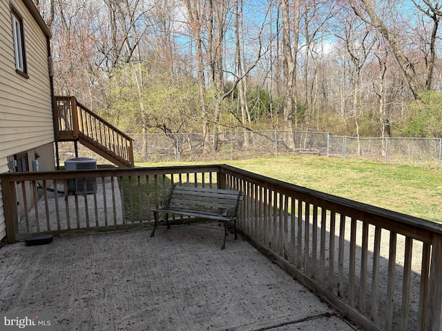 deck featuring a fenced backyard, central AC unit, stairway, and a lawn