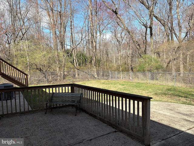 wooden deck featuring a yard, a fenced backyard, and a wooded view
