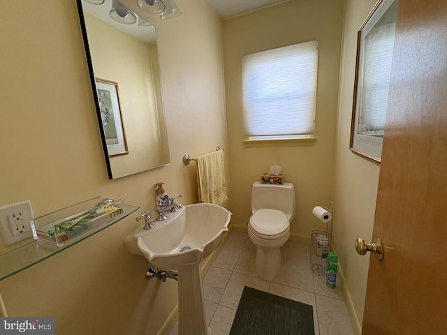 half bathroom featuring toilet, tile patterned flooring, and baseboards
