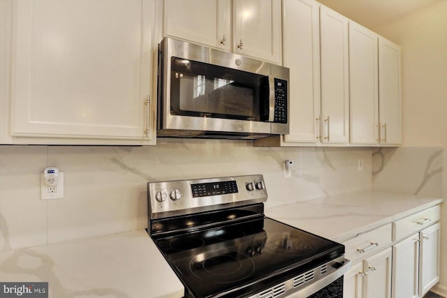 18010 Dave Anne Cir, Stewartstown, PA 17363 - kitchen with appliances with stainless steel finishes, backsplash, white cabinets, and light stone countertops