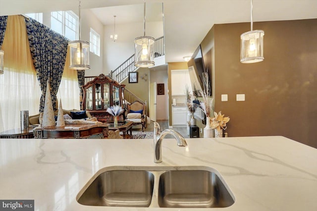 18010 Dave Anne Cir, Stewartstown, PA 17363 - kitchen featuring a sink, light stone counters, hanging light fixtures, a high ceiling, and open floor plan