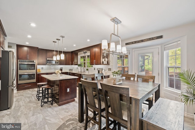 dining room featuring an inviting chandelier, marble finish floor, and recessed lighting