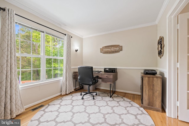 office with crown molding, a wealth of natural light, visible vents, and wood finished floors