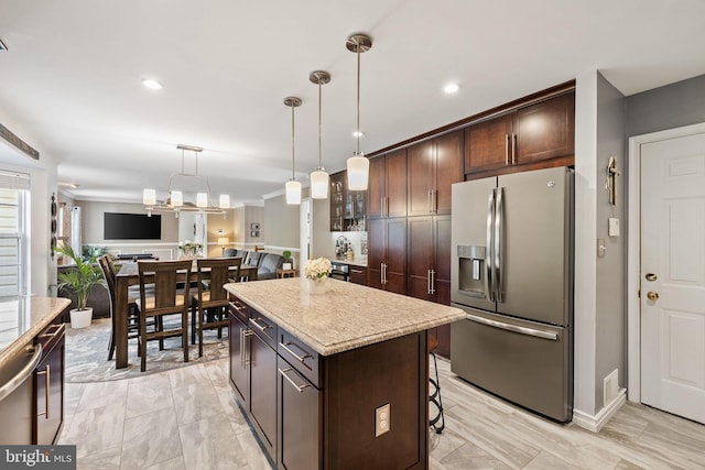 kitchen featuring a breakfast bar, stainless steel refrigerator with ice dispenser, pendant lighting, a kitchen island, and dark brown cabinets