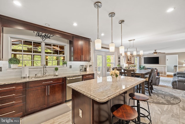 kitchen featuring a sink, open floor plan, a healthy amount of sunlight, and dishwasher